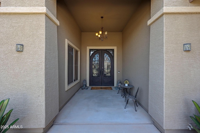 view of exterior entry featuring stucco siding and french doors