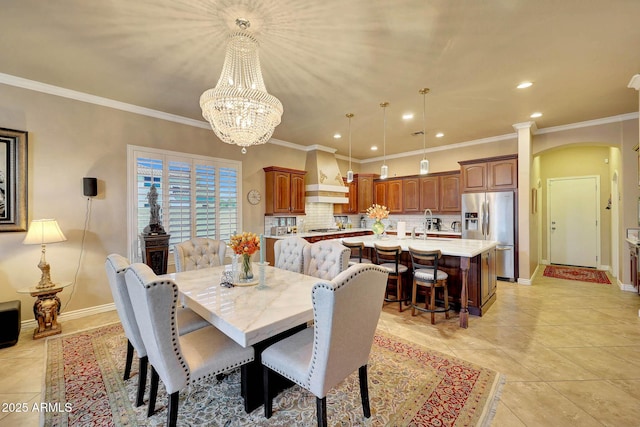 dining room featuring light tile patterned flooring, baseboards, arched walkways, and ornamental molding