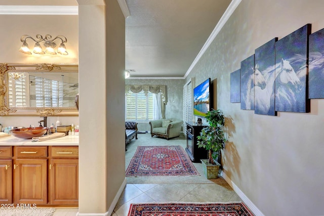 interior space with baseboards, connected bathroom, ornamental molding, tile patterned flooring, and vanity