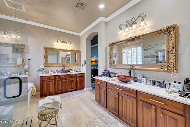 full bath with crown molding, two vanities, visible vents, a sink, and a shower stall