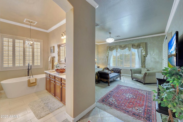 bathroom featuring a freestanding bath, ornamental molding, vanity, and visible vents