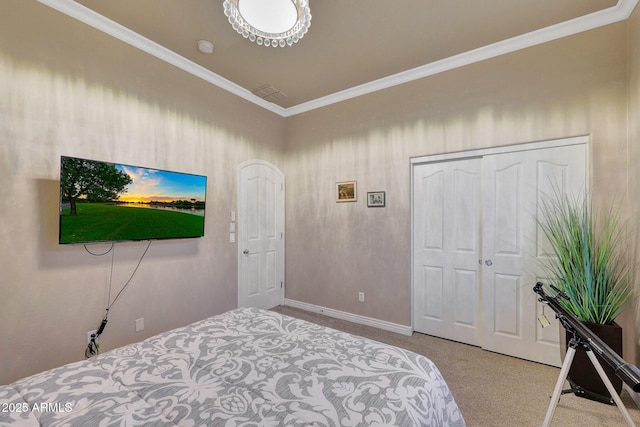 carpeted bedroom featuring baseboards, a closet, and crown molding