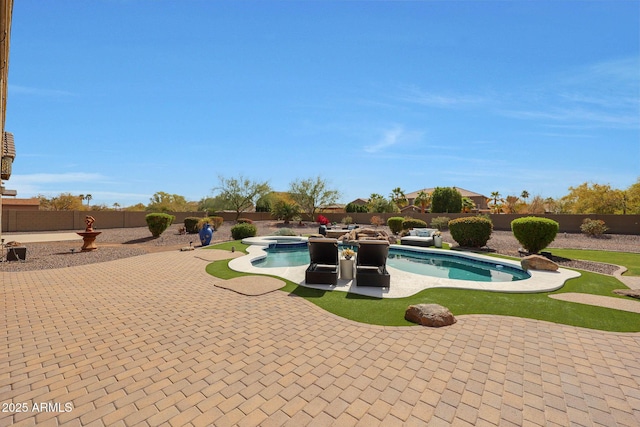 view of swimming pool with a pool with connected hot tub, a patio area, and a fenced backyard