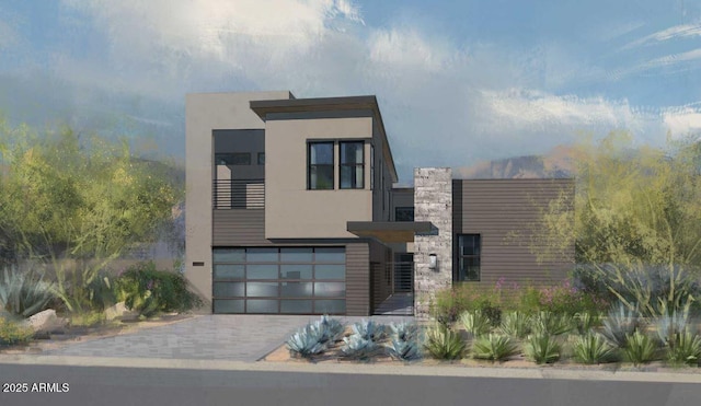 contemporary house with stucco siding, an attached garage, and decorative driveway