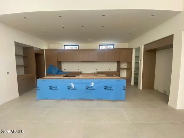 kitchen with light tile patterned flooring, a center island, and modern cabinets