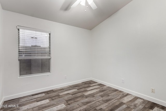 empty room featuring ceiling fan, wood finished floors, baseboards, and vaulted ceiling