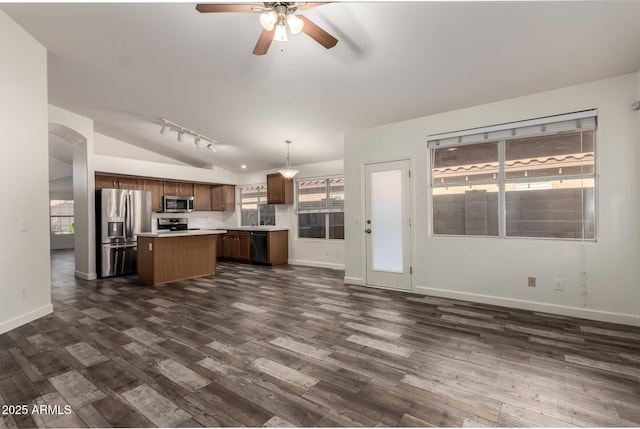 kitchen featuring stainless steel appliances, lofted ceiling, a kitchen island, light countertops, and a ceiling fan