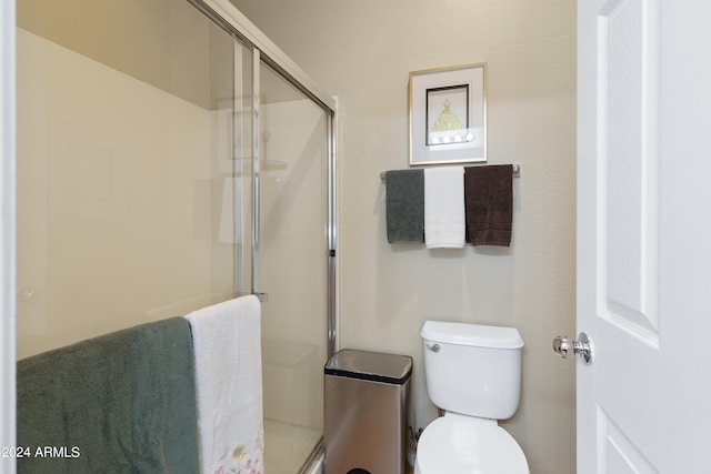 bathroom with toilet and a shower with shower door