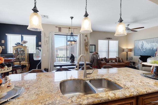 kitchen featuring ceiling fan, hanging light fixtures, sink, and a healthy amount of sunlight