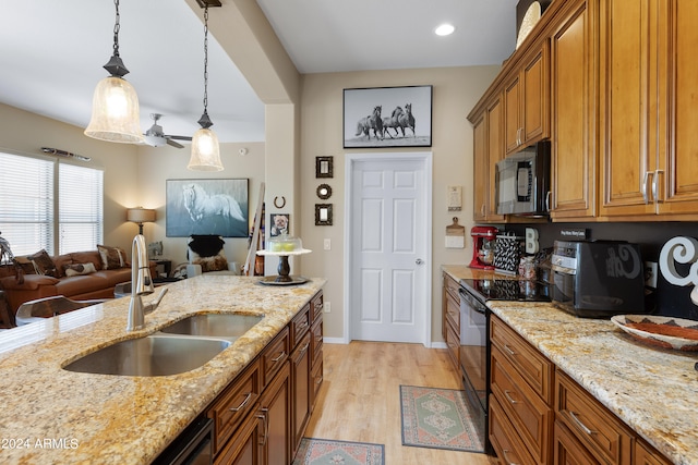 kitchen featuring sink, decorative light fixtures, stainless steel electric stove, light stone countertops, and light hardwood / wood-style floors