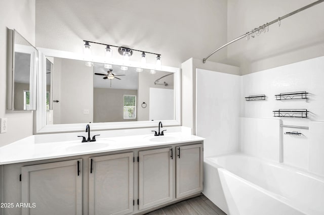 bathroom with shower / bath combination, double vanity, a sink, and a ceiling fan