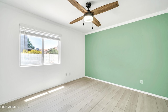unfurnished room featuring baseboards, a ceiling fan, crown molding, and wood finished floors