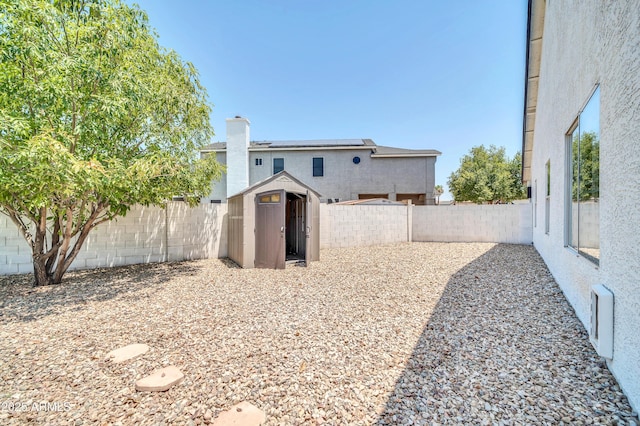 view of yard featuring a fenced backyard, an outdoor structure, and a storage unit