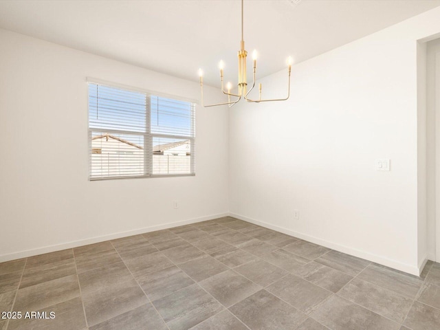 tiled spare room featuring baseboards and a chandelier