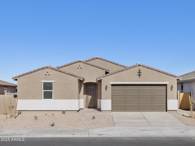 ranch-style home with fence, an attached garage, a tile roof, stucco siding, and driveway