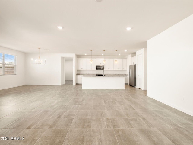 unfurnished living room with recessed lighting, baseboards, and a chandelier