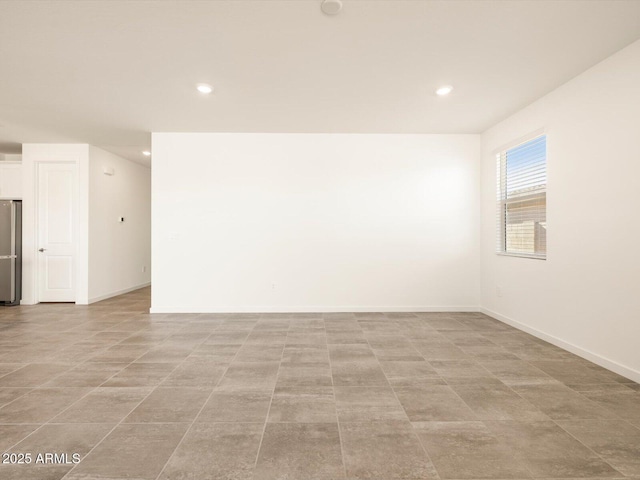 unfurnished room with recessed lighting and baseboards
