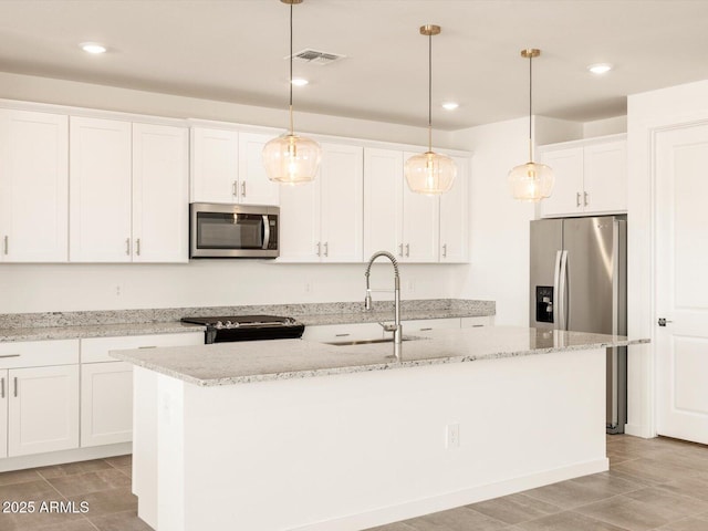 kitchen featuring a sink, appliances with stainless steel finishes, white cabinets, and a kitchen island with sink