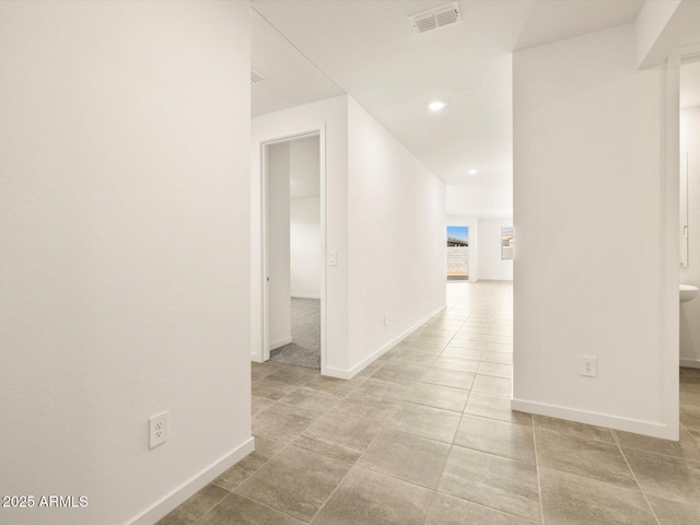 hallway featuring baseboards, recessed lighting, and visible vents