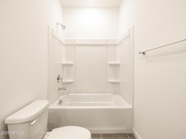 bathroom featuring shower / washtub combination, tile patterned floors, and toilet