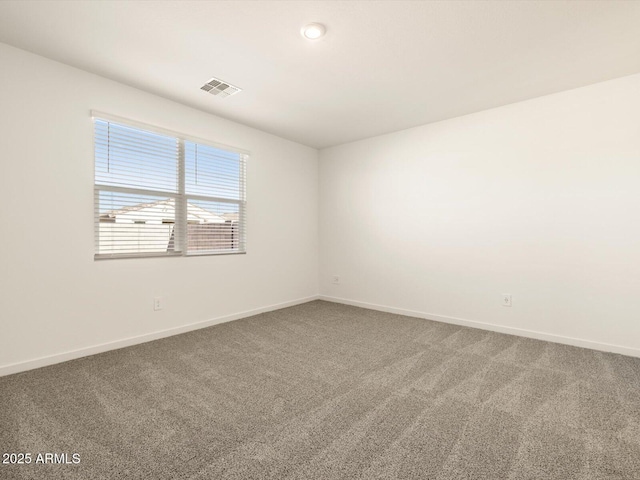empty room with baseboards, carpet flooring, and visible vents