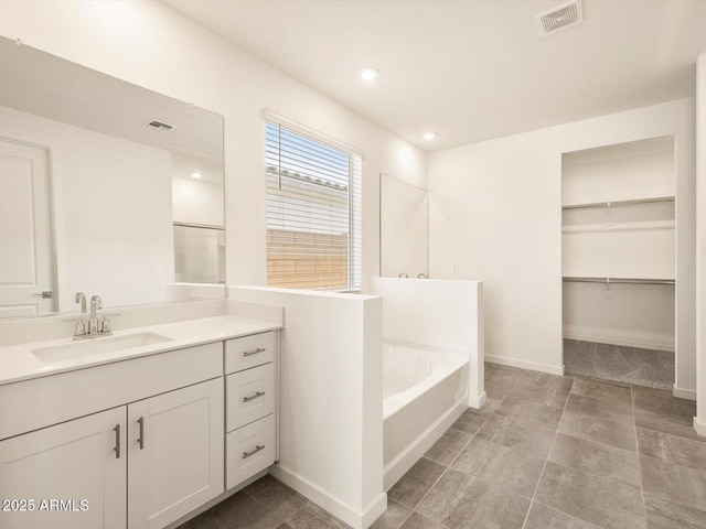 full bath with visible vents, vanity, baseboards, recessed lighting, and a bath