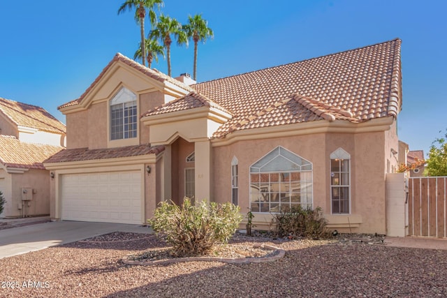 mediterranean / spanish home with driveway, a chimney, an attached garage, and stucco siding