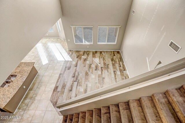 stairs with tile patterned flooring and a high ceiling