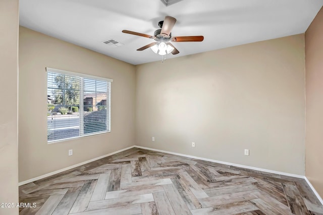 empty room featuring ceiling fan and light parquet flooring