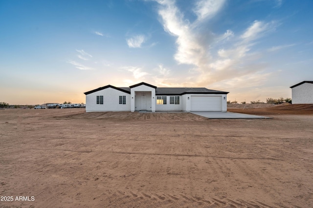 single story home with concrete driveway and an attached garage