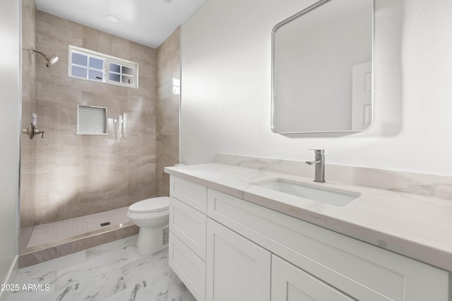 full bath featuring toilet, marble finish floor, tiled shower, and vanity