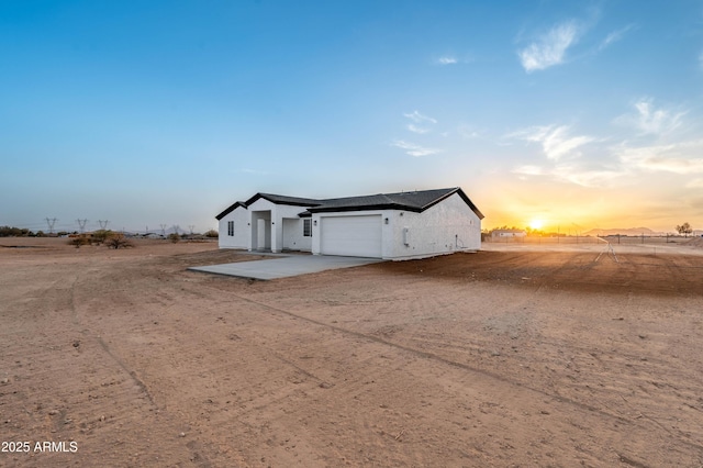 exterior space featuring an attached garage, concrete driveway, and stucco siding