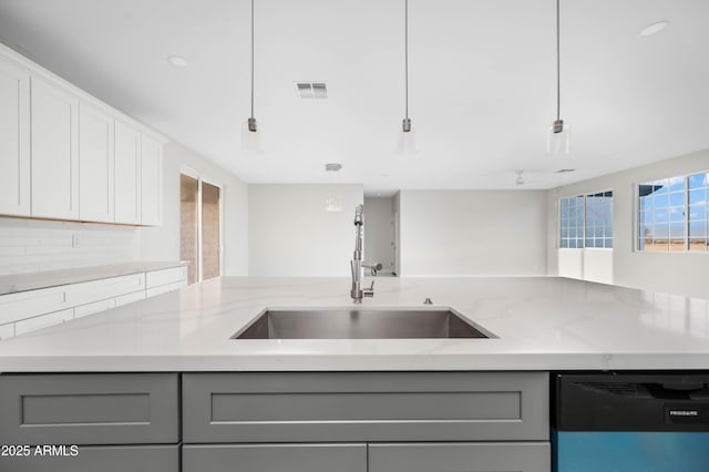 kitchen with gray cabinets, visible vents, a sink, and dishwashing machine