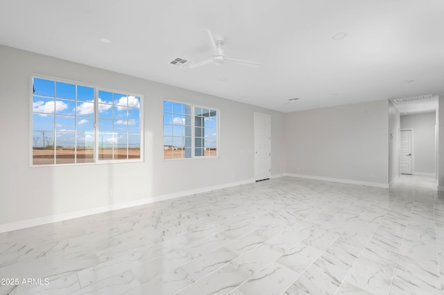 unfurnished room with marble finish floor, baseboards, visible vents, and a ceiling fan