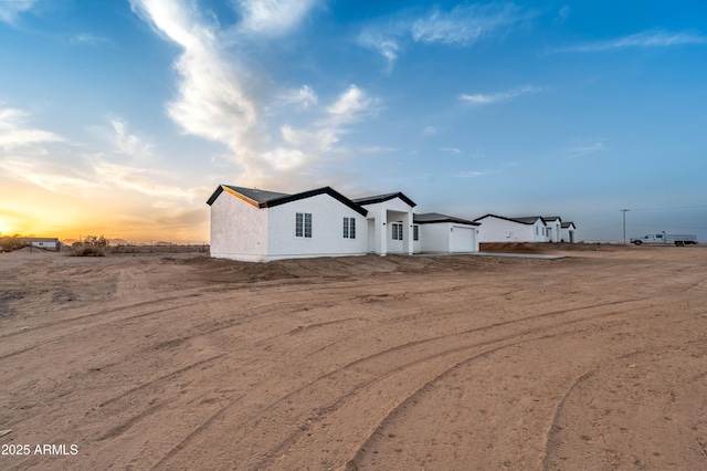 view of side of property featuring a garage and stucco siding