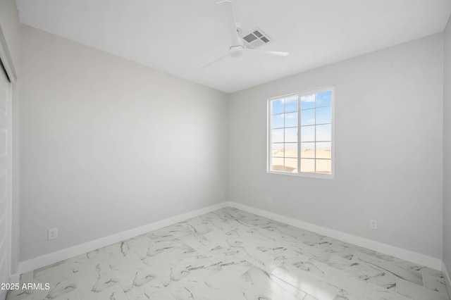 spare room featuring a ceiling fan, marble finish floor, visible vents, and baseboards