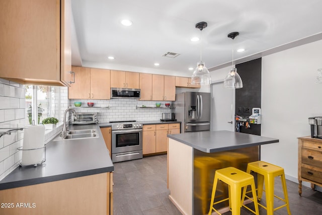2062 S Emerson, Mesa, AZ 85210 - kitchen featuring stainless steel appliances, dark countertops, decorative backsplash, light brown cabinets, and a kitchen breakfast bar