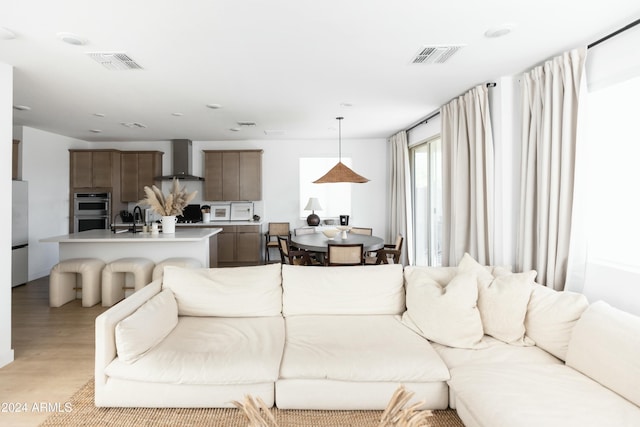 living room featuring sink and light hardwood / wood-style flooring