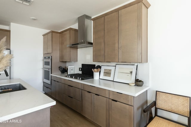 kitchen featuring appliances with stainless steel finishes, sink, light hardwood / wood-style floors, and wall chimney exhaust hood