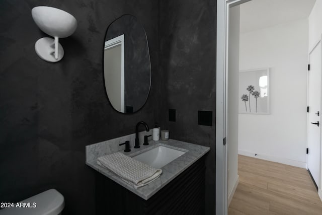 bathroom featuring toilet, hardwood / wood-style flooring, and vanity