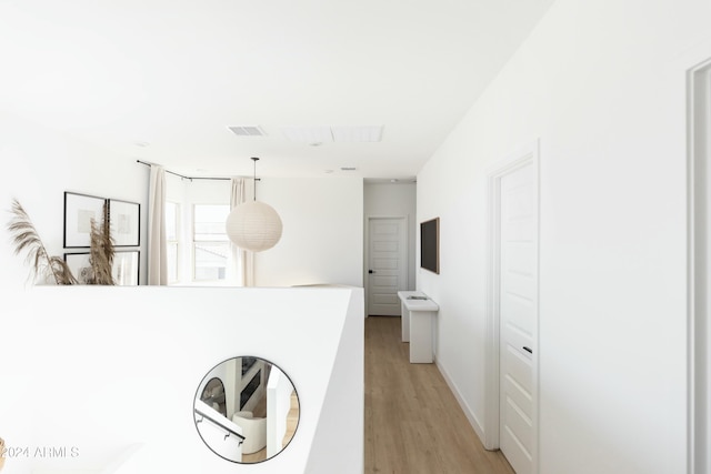 interior space with light hardwood / wood-style floors and pendant lighting