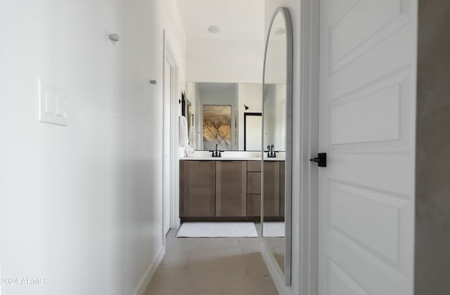 corridor featuring sink and light tile patterned flooring