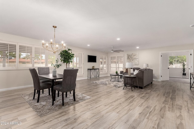 dining room with plenty of natural light, light hardwood / wood-style floors, and ceiling fan with notable chandelier