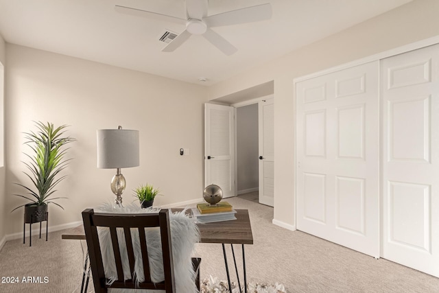 carpeted home office featuring ceiling fan