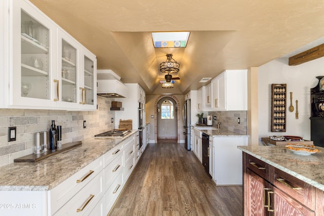 kitchen featuring dark hardwood / wood-style flooring, premium range hood, stainless steel appliances, a tray ceiling, and sink