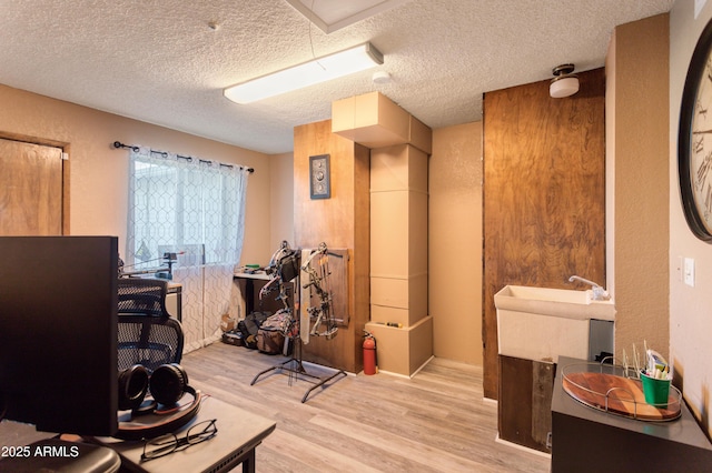 office with light hardwood / wood-style floors and a textured ceiling