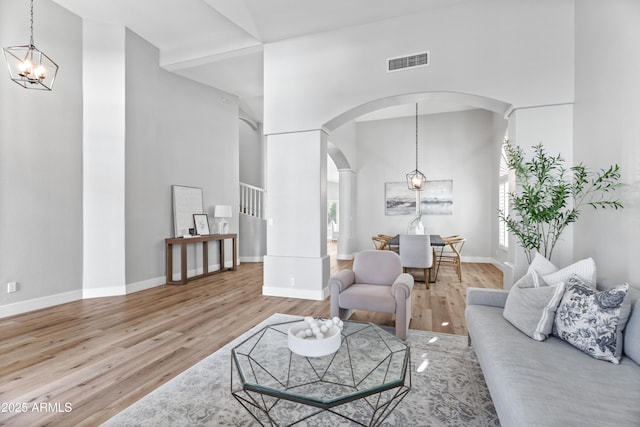 living room with a notable chandelier, a high ceiling, and hardwood / wood-style floors