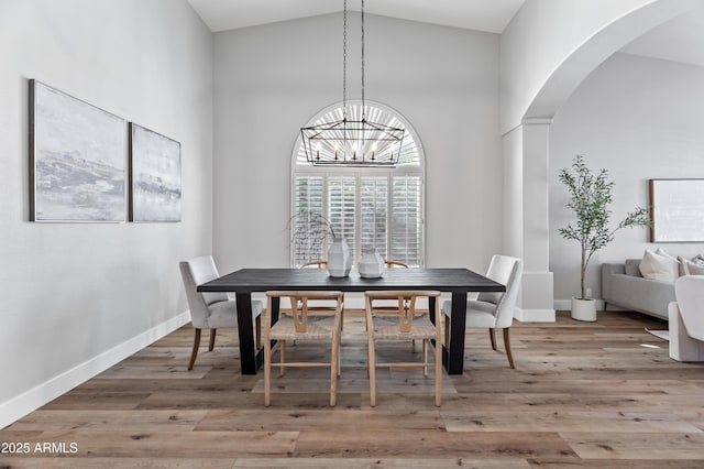 dining room with a chandelier, hardwood / wood-style floors, and high vaulted ceiling