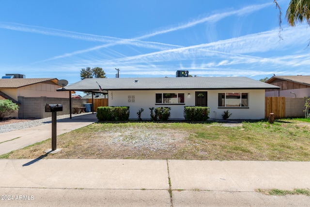 single story home featuring a front lawn and a carport