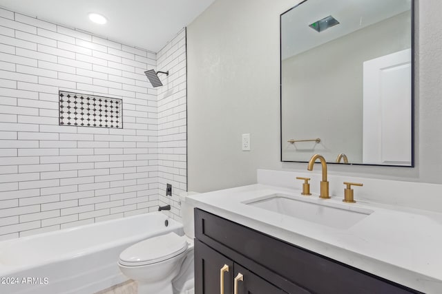 full bathroom with tiled shower / bath, vanity, and toilet